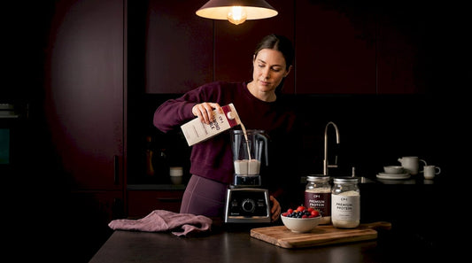 Woman preparing healthy protein shake in kitchen
