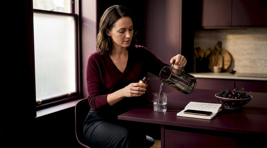Woman at kitchen table with supplements and water