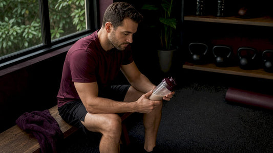 Athlete reviewing ergogenic aid supplement in gym