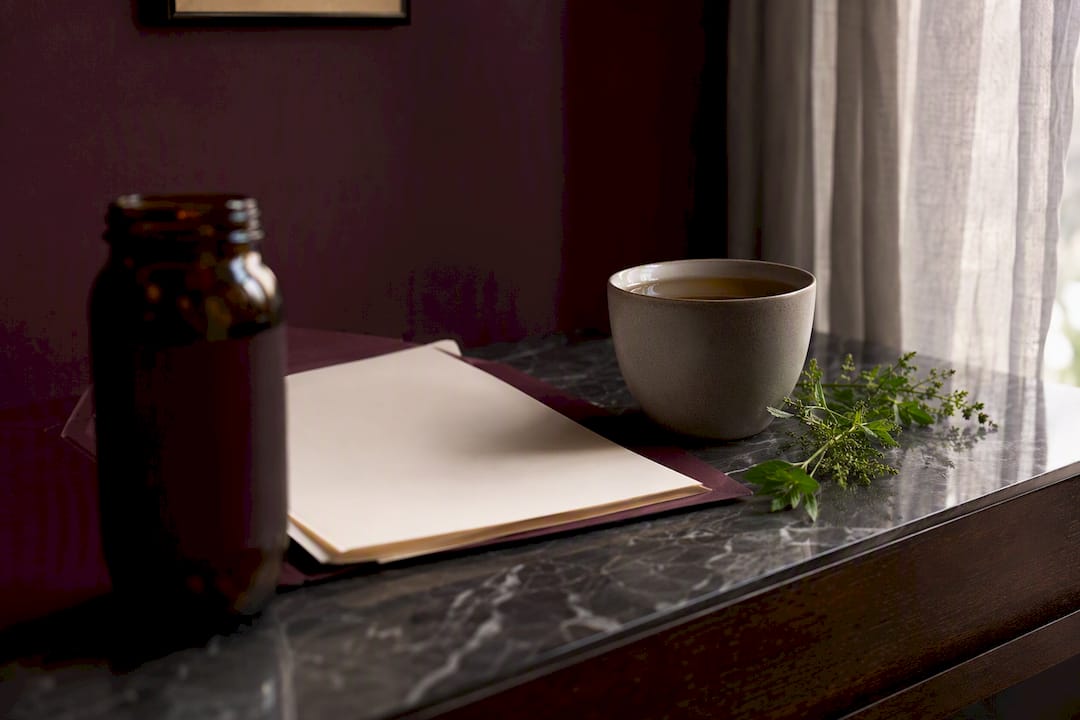 NMN supplement bottle with paperwork on dark plum table