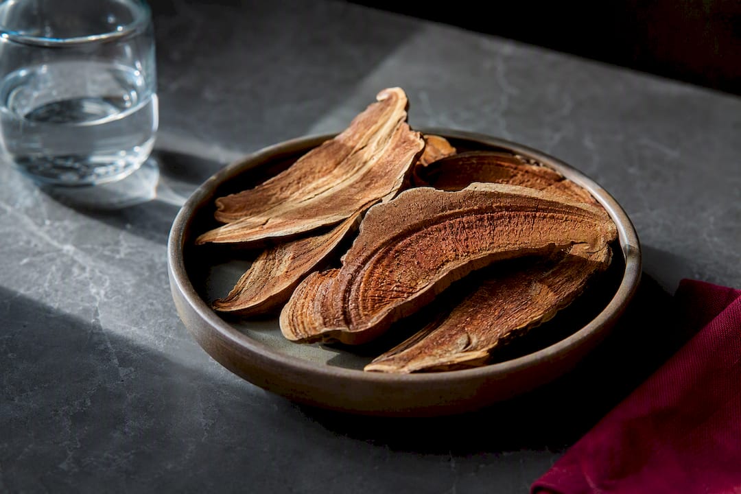 Dried reishi slices beside water