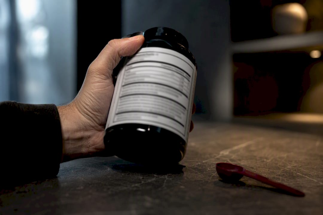 Hand inspecting an anonymous supplement label
