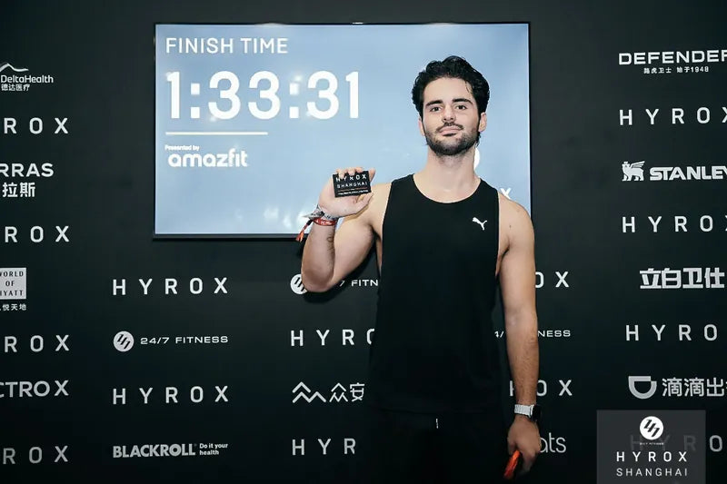 Hugo Sandjian, founder of CP-1, holding his HYROX Shanghai finisher card in front of a screen showing a finish time of 1:33:31.
