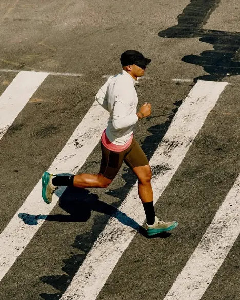 A runner crossing a city street